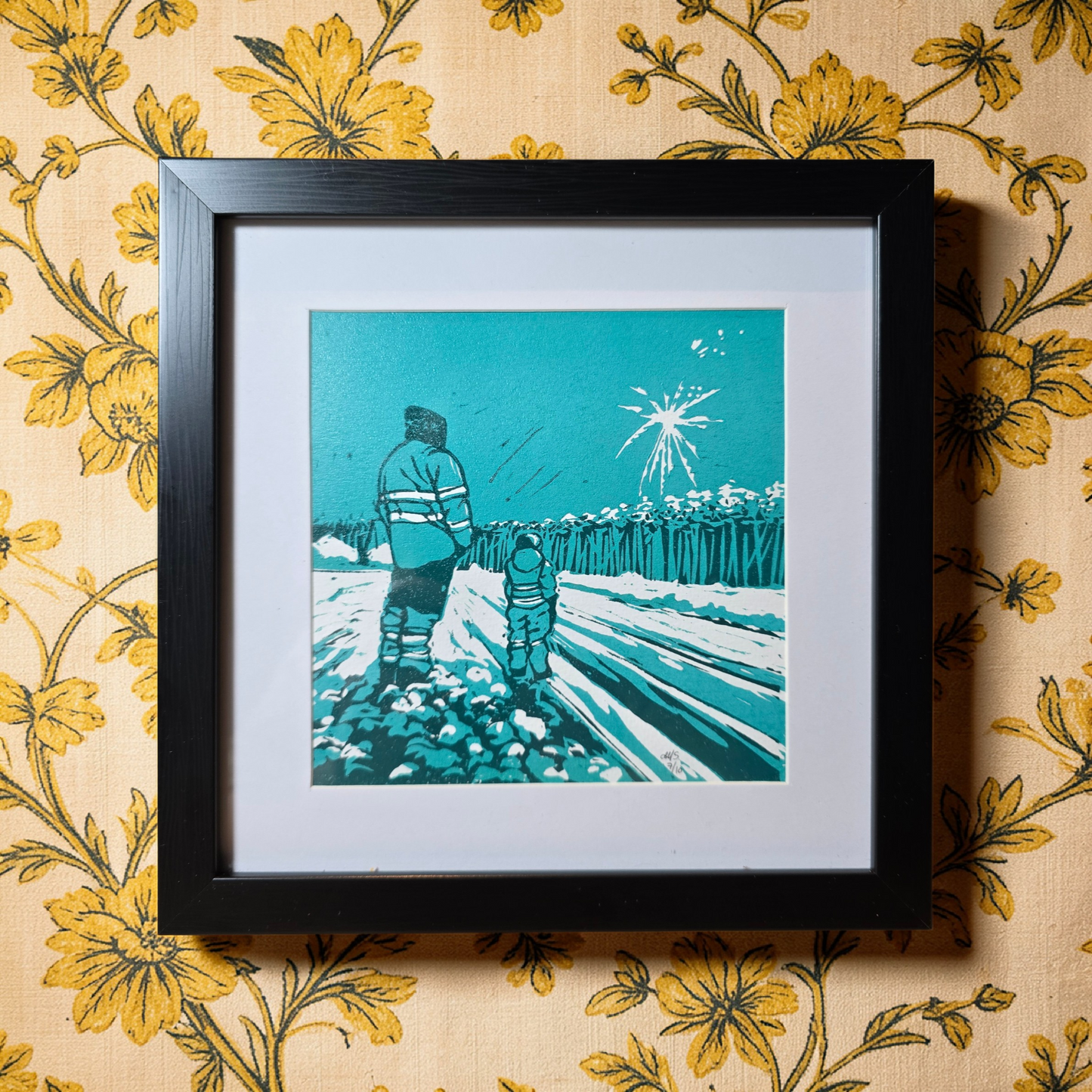Unikt linotrykk, nummerert 7 av 10. Innrammet i svart ramme av kunststoff. Måler 22 x 22 cm. Motivet er av far og sønn som står sammen og ser nyttårsfyrverkeri, en hyggelig delt opplevelse. Fargene i bildet er mørke og lys grønnblå tone og hvitt i arket. Kunstner monica Sandmo