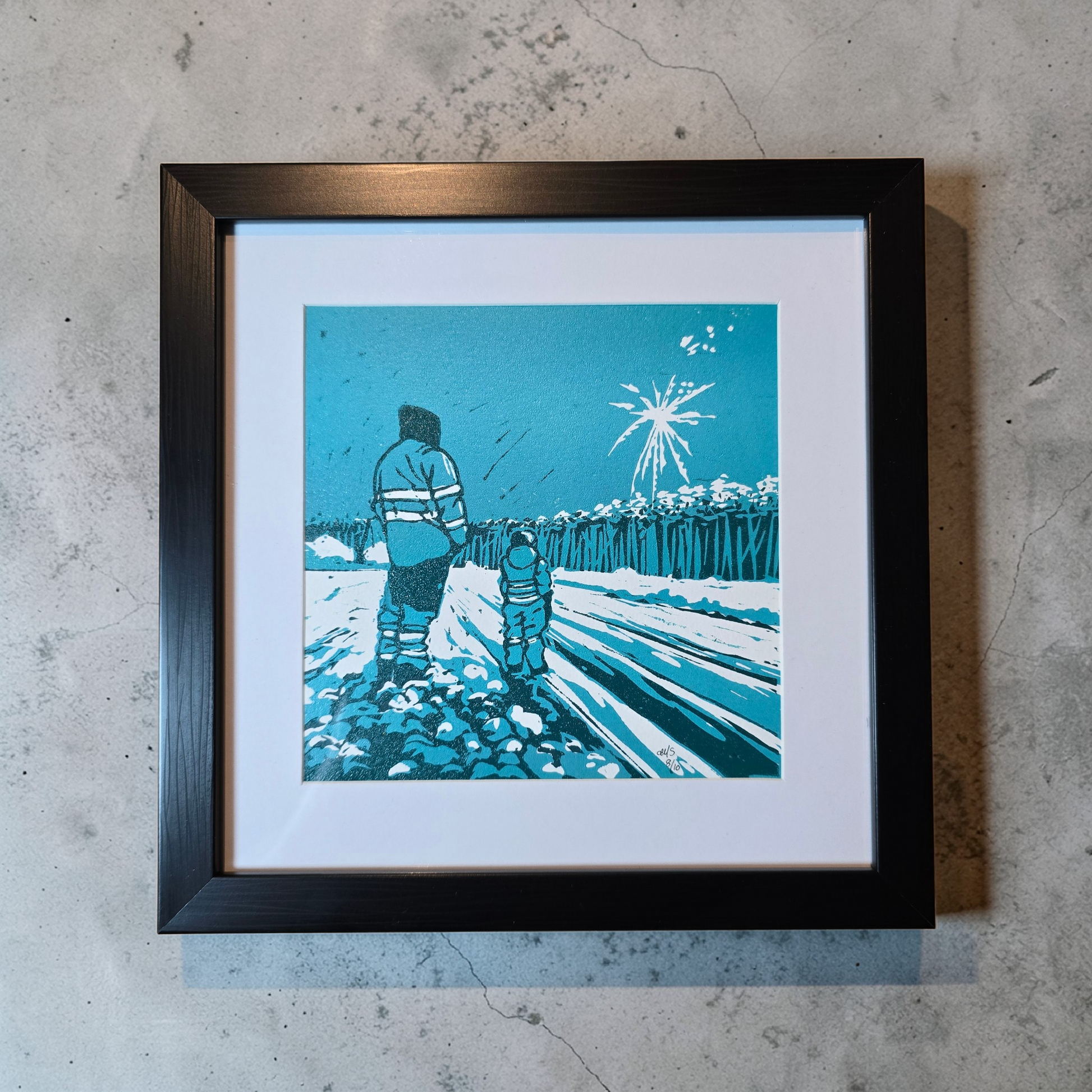 Linotrykk Far og sønn. Dette er nummerert  8 av 10.Trykket viser en far og sønn som står og ser nyttårsfyrverkeri sammen. En koselig stund. Trykket er trykket i blågrønt, mørk og lyst. så er det også hvitt fra arket. Hvit passeopartout og svart ramme i kunststoff.